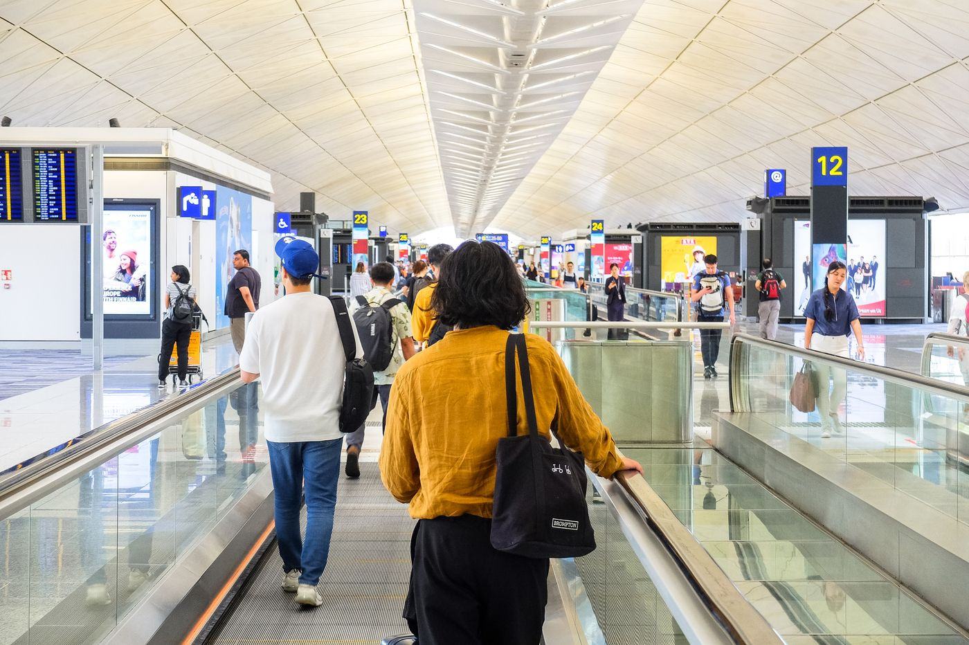Travellers checking phones in an airport terminal