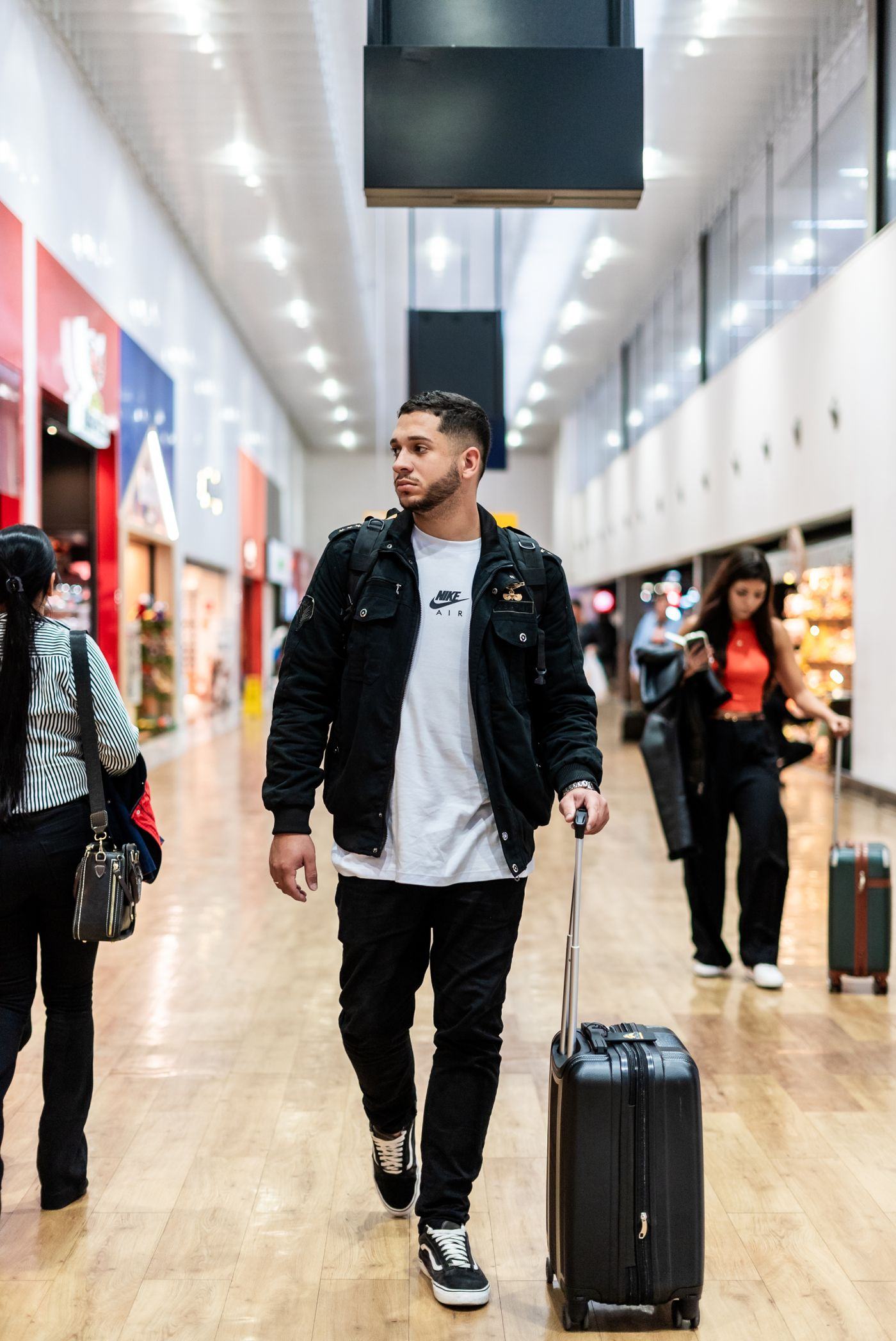 A traveller waiting in an airport terminal, phone in hand