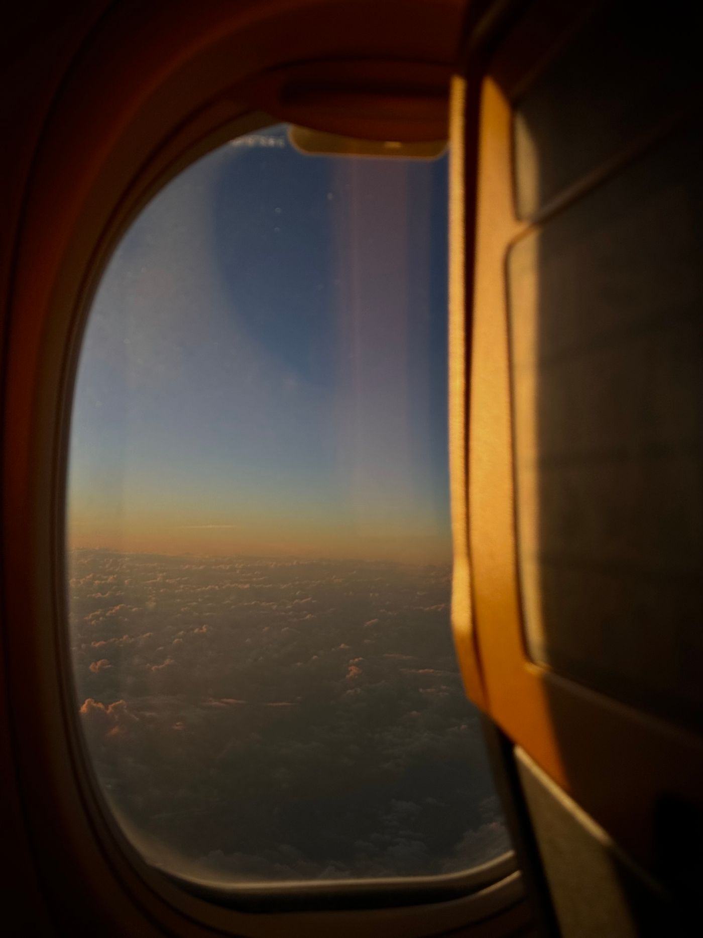 An aircraft climbing away from an airport at sunset