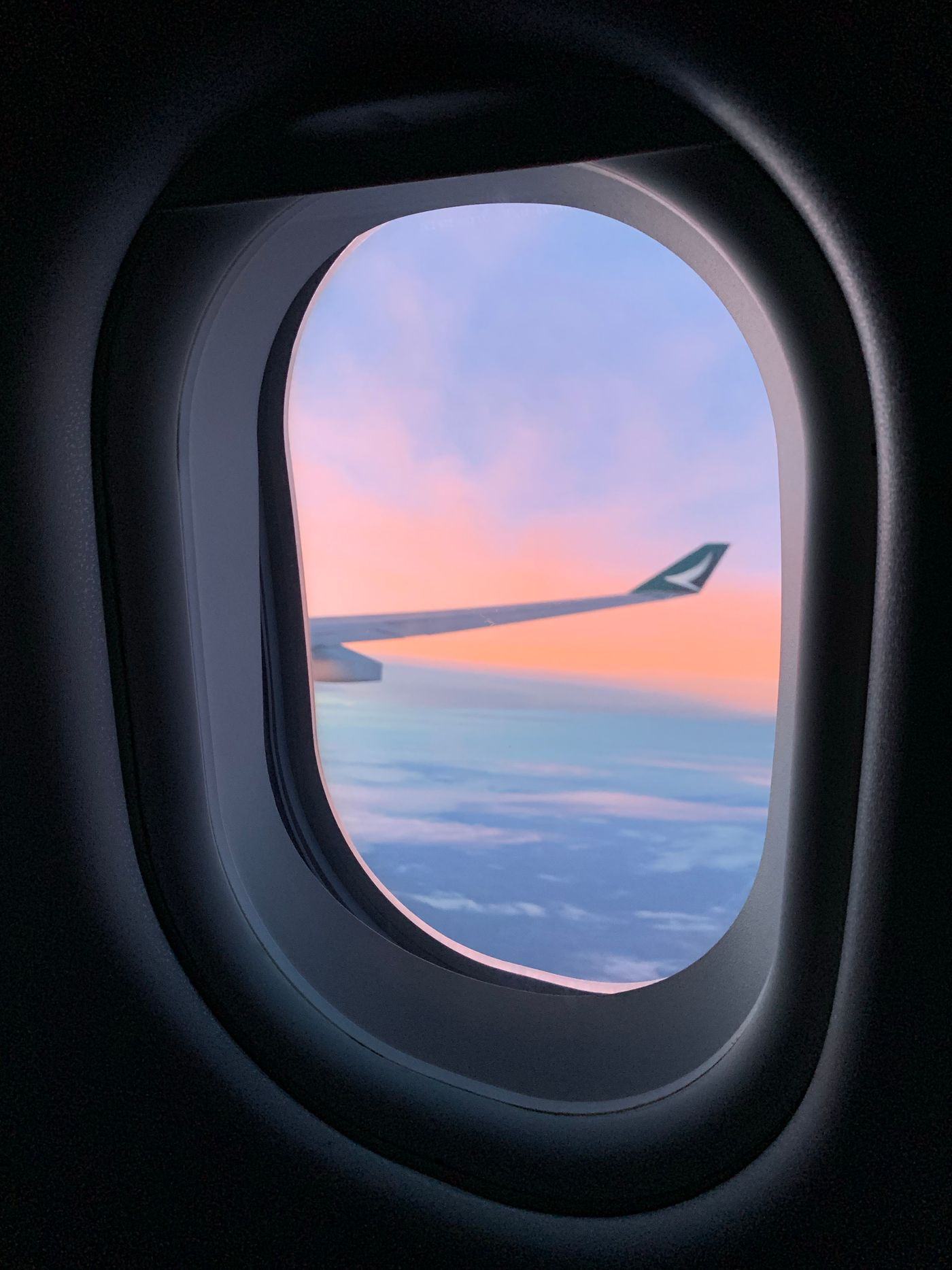 An aircraft wing above a layer of cloud at altitude